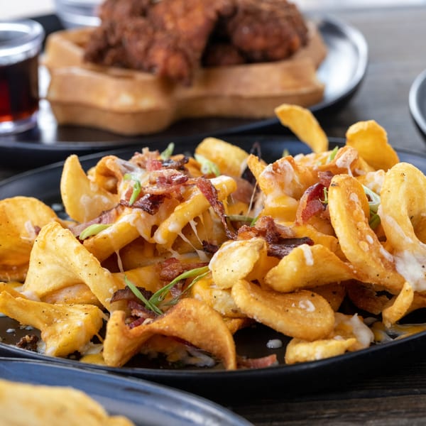 Loaded Fairway Pizza & Sports fries with melted cheese, bacon, and green onions.